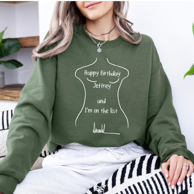 K&ouml;nnte beinhalten: Olivgr&uuml;nes Sweatshirt mit wei&szlig;em Text "Happy Birthday Jeffrey and I'm on the list". Der Text wird von einer wei&szlig;en Umrisszeichnung eines K&ouml;rpers begleitet. Das Sweatshirt ist einfarbig und hat lange &Auml;rmel.