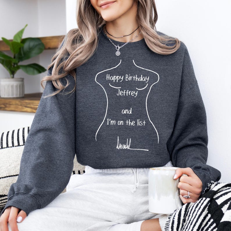 K&ouml;nnte beinhalten: Dunkelgraues Sweatshirt mit wei&szlig;em Text, der lautet: "Happy Birthday Jeffrey and I'm on the list". Der Text befindet sich innerhalb einer wei&szlig;en Umrisszeichnung eines Torsos. Die Person h&auml;lt einen wei&szlig;en Becher.