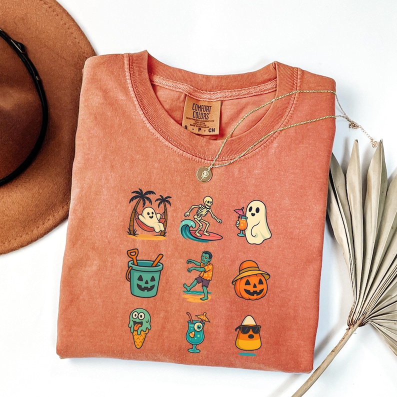 May include: Coral-colored Comfort Colors sweatshirt featuring a grid of cartoon graphics. Designs include a ghost in a hammock, a skeleton surfing, a ghost with a drink, a bucket, a zombie, a jack-o'-lantern, ice cream, a cocktail, and a candy corn.