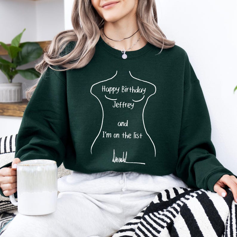 K&ouml;nnte beinhalten: Dunkelgr&uuml;nes Sweatshirt mit wei&szlig;em Text, der lautet: "Happy Birthday Jeffrey and I'm on the list". Der Text befindet sich innerhalb einer wei&szlig;en Umrisslinie eines Torsos. Eine wei&szlig;e Tasse wird in der Hand gehalten.