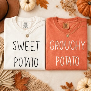 May include: Two crewneck t-shirts, one white and one burnt orange, each featuring a Comfort Colors label at the inner neckline. The white shirt displays the black text SWEET POTATO, while the orange shirt displays the white text GROUCHY POTATO.