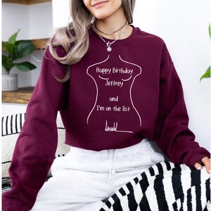 K&ouml;nnte beinhalten: Ein weinrotes Sweatshirt mit wei&szlig;em Text, der "Happy Birthday Jeffrey and I'm on the list" und eine Strichzeichnung eines Torsos zeigt. Das Sweatshirt ist einfarbig und hat einen Rundhalsausschnitt.