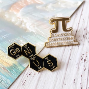 Peut inclure: Trois épingles émaillées sur fond clair. L'une est dorée et blanche avec le symbole pi et des chiffres. La seconde épingle épelle "Ge Ni Us" en hexagones noirs et dorés. Les épingles sont probablement pour un passionné de sciences ou de mathématiques.