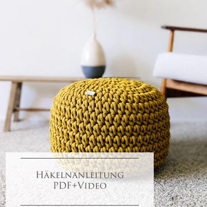 Op de afbeelding: Een gele gehaakte voetenbank met de tekst "HÄKELN Anleitung PDF+VIDEO" op een witte achtergrond.
