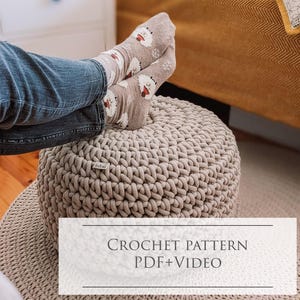 Könnte beinhalten: Häkelmuster PDF + Video für einen beigen Strickhocker. Der Hocker ist rund und hat eine strukturierte Oberfläche.