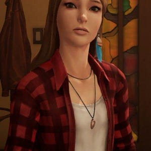 May include: A young woman with long brown hair wearing a red and black plaid shirt over a white t-shirt. She is wearing a black necklace with a pendant and blue feather earrings.