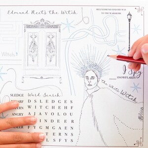 May include: A black and white activity sheet with the text "Edmund Meets the Witch." The sheet features illustrations of a wardrobe, a witch, and a word search puzzle. A hand holds a red pencil, ready to complete the activities.
