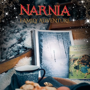 May include: A close-up of a book titled "The Lion, the Witch and the Wardrobe" by C.S. Lewis, with a snowy forest scene on the cover. The book is sitting on a wooden surface with a blue mug and a spiral-bound journal with a similar snowy forest scene on the cover. The text "Narnia Family Adventure" is displayed above the book.