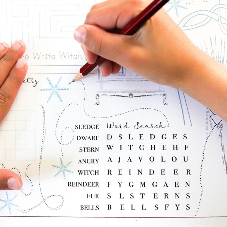 May include: A person's hand using a red pencil to circle words on a white paper word search puzzle. The puzzle includes words like "SLEDGE", "DWARF", and "REINDEER". The puzzle has snowflake illustrations and the text "The White Witch".