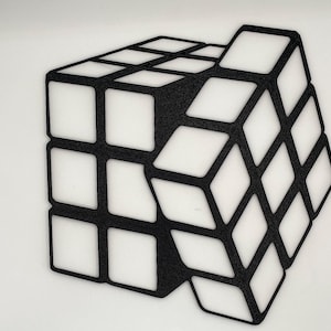 May include: A black and white 3D printed model of a Rubik's Cube. The cube is made of individual squares that are connected together. The model is a great way to add a touch of modern art to any room.