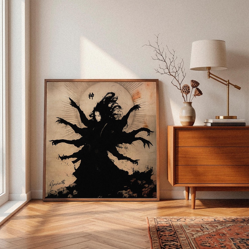 May include: A framed print featuring a black silhouette of a multi-armed figure with long hair, set against a pale circular background. The artwork includes Japanese characters and the artist's signature. The print is displayed in a room with a wooden floor and furniture.