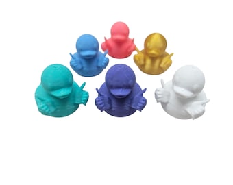 Puede incluir: Colección de seis figuras de patos coloridos en tonos turquesa, azul, rosa, dorado, morado y blanco. Cada pato está posando con los pulgares hacia arriba. Los patos están hechos de un material texturizado.