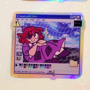 May include: A digital art sticker featuring a cartoon girl with red hair and a purple dress. The girl is in a Windows Paint window with a blue and white grid background. The text "Ragatha.EXE - Paint" is at the top of the window.