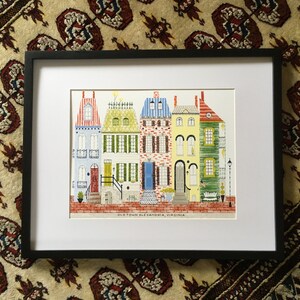 May include: A framed illustration of five colorful row houses with red brick sidewalks and the text "Old Town Alexandria, Virginia".