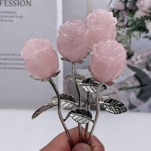 May include: A bouquet of four pink rose quartz flowers with silver stems and leaves.