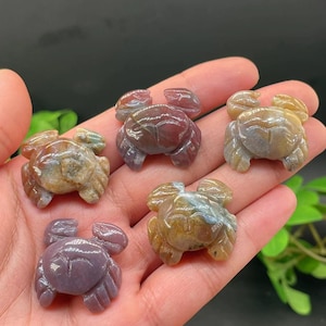 May include: Five carved agate crab figurines in various shades of brown, red, and purple. The crabs are about 2 inches long and are made of polished agate.