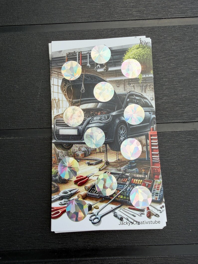 May include: A rectangular sticker sheet featuring a detailed illustration of a black car with its hood open inside a workshop, surrounded by various tools and equipment. The sheet is decorated with ten circular holographic stickers.