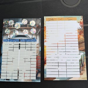 May include: Two rectangular paper tracking sheets with grid lines for recording data. The left sheet features a garage scene with holographic circles at the top. The right sheet displays an autumn road scene with a car. Both include the text Datum, +/-, Summe.