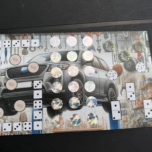 May include: A rectangular sticker sheet featuring a gray SUV illustration in a garage setting. The design includes various circular holographic stickers, square dice-patterned stickers, and rectangular domino-patterned stickers arranged around the vehicle.