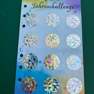 Könnte beinhalten: Ein Blatt mit 12 regenbogenfarbenen, holografischen Aufklebern mit dem Text "Mini Jahreschallenge".