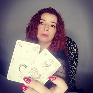 Psychic reader holding Lenormand cards featuring symbols such as the Ring and the Heart, representing love, commitment, and emotional guidance. This image illustrates a professional lenormand cards reading and psychic reading session focused on relationships, clarity, and intuitive insights, offering accurate future reading through traditional Lenormand divination cards.