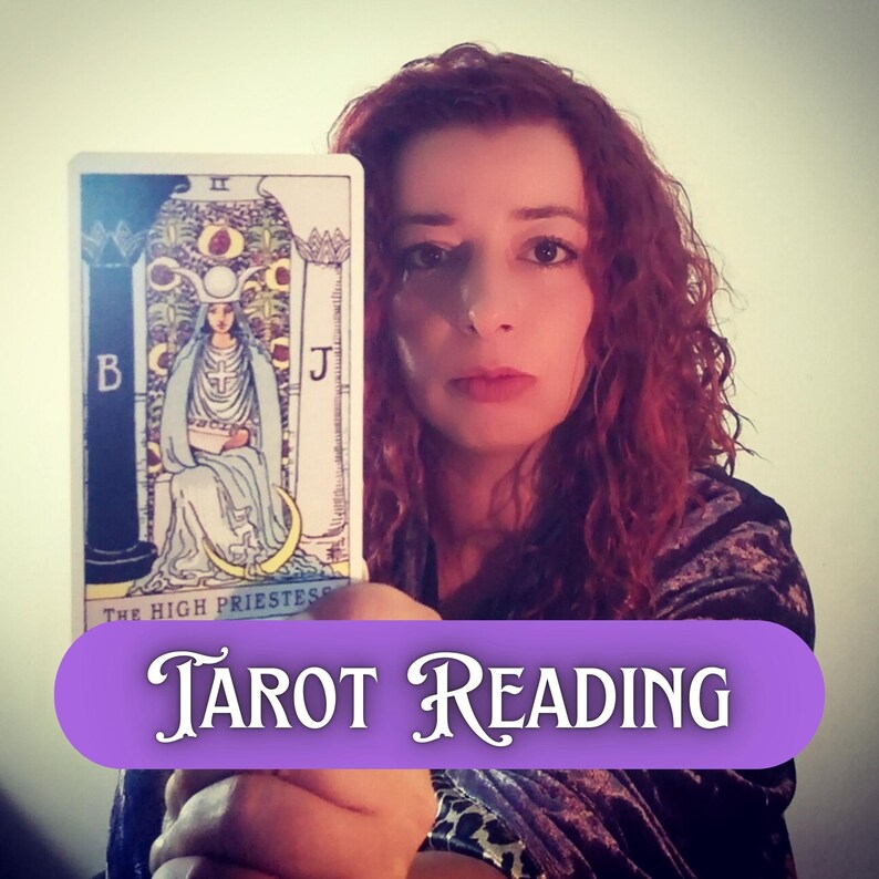 Tarot reading image showing a psychic medium holding The High Priestess tarot card close to the camera. The reader has red curly hair and a calm, intuitive expression, symbolizing deep spiritual insight, intuition, and hidden knowledge. This future reading visual represents clarity, wisdom, and intuitive guidance offered through professional tarot reading and psychic medium services.