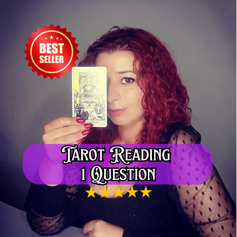 A professional psychic medium with curly red hair holds a tarot card, The Chariot, partially covering her face while looking directly at the camera. She wears a black top with sheer sleeves and red nail polish, photographed against a neutral gray background. The image promotes a tarot reading service for one question with five-star rating. It represents tarot reading, psychic medium guidance, intuitive insight, and future reading for clarity, direction, and spiritual support.