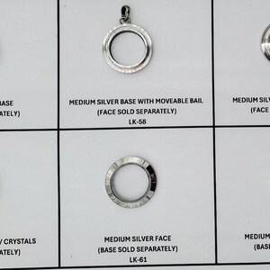 May include: A collection of silver-toned pendant bases and faces, including a base with a moveable bail, a face with crystals, and a shimmer face. Each piece is labeled with text, including "Medium Silver Base" and "Face Sold Separately."
