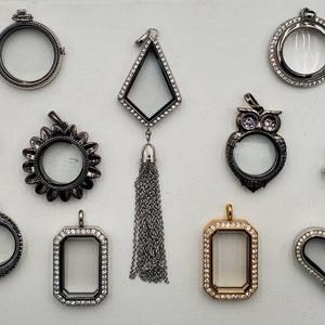 May include: A collection of various floating locket charms in different shapes and designs. Charms include a Minion, teardrop, sunflower, owl, Christmas tree, heart, and geometric shapes. Most are silver-toned with clear centers, some with crystal accents.