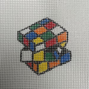 May include: A colorful, multi-sided cube with a black outline. Each side of the cube is a different color, including red, blue, green, yellow, orange, and white.