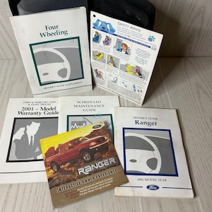 May include: A collection of 2001 Ford Ranger owner manuals and guides, including a Four Wheeling supplement, a warranty guide, a scheduled maintenance guide, a safety advice card featuring Blue's Clues, and an interactive owner experience CD case.
