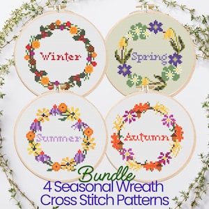 May include: Four cross stitch patterns for wreaths, each representing a different season. The wreaths are decorated with flowers and foliage in colors associated with each season. The words "Winter", "Spring", "Summer", and "Autumn" are stitched in the center of each wreath.