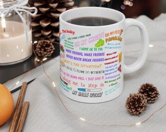 May include: White ceramic mug with a colorful design featuring quotes from the popular TV show "Friends". The quotes are in a variety of colors and fonts, and they are arranged in a random pattern. The mug is filled with coffee and has a handle on the right side.