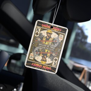 May include: A rectangular car air freshener featuring a playing card design with a central illustration of an electrician in a hard hat and safety vest. The text reads Union Sparky, Skilled by Trade, Powering the Future, Built with Pride, and Success for Wired.