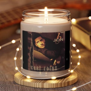 May include: A brown glass candle with a white label featuring a man's face and the text "JON cool relax".