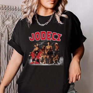 May include: Black t-shirt with a red "Jodeci" graphic featuring a group of men in a vintage photo.