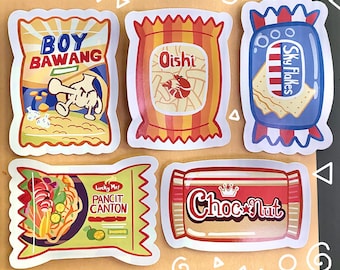 May include: Five colorful stickers with cartoon illustrations of different snacks. The stickers feature the text "Boy Bawang", "Oishi", "Sky Flakes", "Lucky Me! Pancit Canton", and "Choc-Nut".