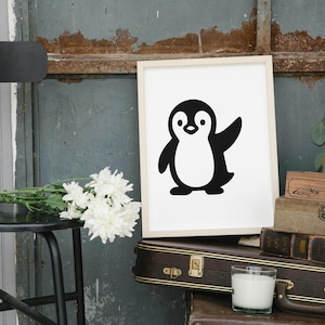 May include: A framed print featuring a black and white cartoon penguin with a raised wing. The artwork is displayed on a white background. The image is set against a rustic backdrop with a black chair, flowers, and vintage luggage.
