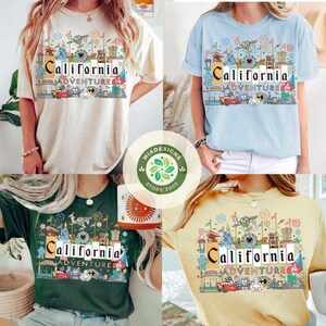 May include: Four different color t-shirts with a graphic print of a California Adventure theme park. The shirts are all short-sleeved and crew neck. The graphic print features a colorful illustration of the park's iconic landmarks, including the Sleeping Beauty Castle, the Matterhorn, and the Cars Land.