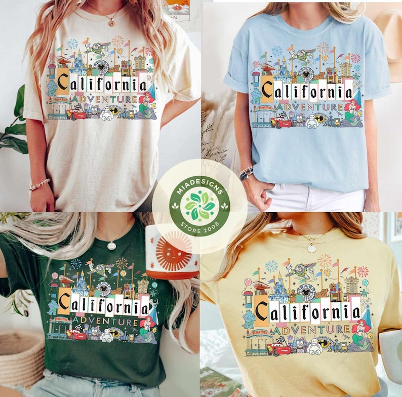 May include: Four different color t-shirts with a graphic print of a California Adventure theme park. The shirts are all short-sleeved and crew neck. The graphic print features a colorful illustration of the park's iconic landmarks, including the Sleeping Beauty Castle, the Matterhorn, and the Cars Land.