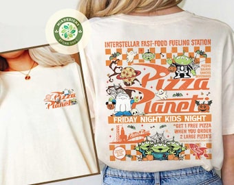 May include: Cream-colored t-shirt featuring the Pizza Planet logo on the front and a larger graphic on the back. The back graphic includes the text "INTERSTELLAR FAST-FOOD FUELING STATION" and "FRIDAY NIGHT KIDS NIGHT" with cartoon aliens, ghosts, and pizza.