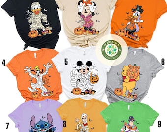 Op de afbeelding: Een verzameling van negen Halloween-thema T-shirts met verschillende Disney-personages. Elk shirt heeft een ander personage verkleed in een Halloween-kostuum, zoals een mummie of vampier, met pompoenen en spinnenwebben. De shirts zijn in verschillende kleuren.