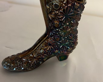 May include: A dark iridescent glass boot shaped vase with a starburst pattern.