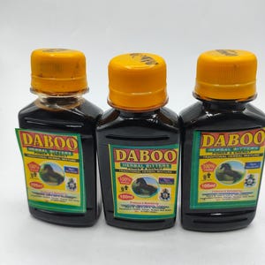 Może przedstawiać: Wyświetlane są trzy butelki z ciemnego szkła z żółtymi zakrętkami. Każda butelka ma zielono-żółtą etykietę z napisem "DABOO HERBAL BITTERS" i ilustracją konia. Butelki zawierają 100 ml płynu.