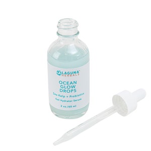 May include: A clear glass bottle with a blue label that reads "LAGUNA HERBALS OCEAN GLOW DROPS Sea Kelp + Probiotics Gel Hydrator Serum 2 oz./60 ml". The bottle has a dropper attached.