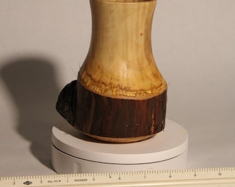 May include: A wooden vase with a natural wood finish. The vase is made from a tree trunk and has a natural bark texture. The vase is about 6 inches tall.