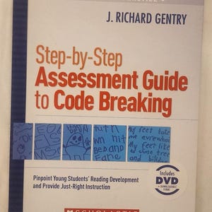 May include: A book titled "Step-by-Step Assessment Guide to Code Breaking" by J. Richard Gentry. The cover is white with red and orange text. Includes a DVD. Features handwritten notes and drawings.
