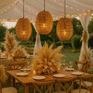 May include: An outdoor dining scene with a wooden table set for a gathering. Three woven pendant lights hang above the table. The table is decorated with plates, glasses, and a floral centerpiece. String lights are strung overhead.