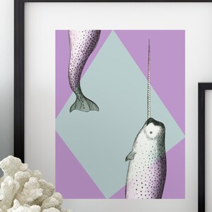 May include: Framed art print featuring a detailed illustration of a narwhal with a long tusk, set against a geometric background of lavender and light blue. The artwork is in a black frame, suitable for wall decor.