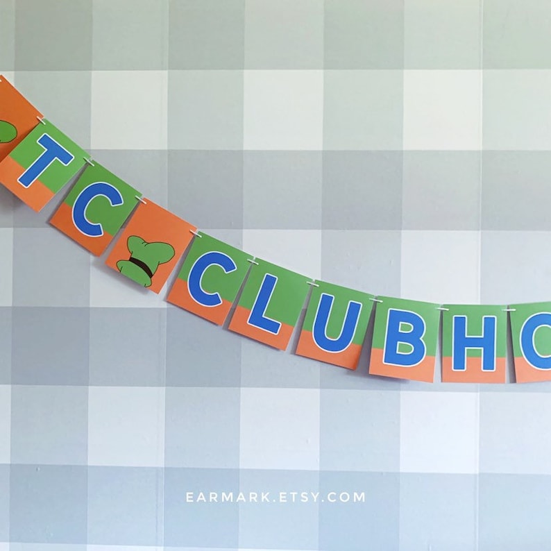 May include: A green, orange, and blue banner with the text "T.C. CLUBHOUSE" in white letters. The banner is strung up on a wall with a white and gray checkered pattern.